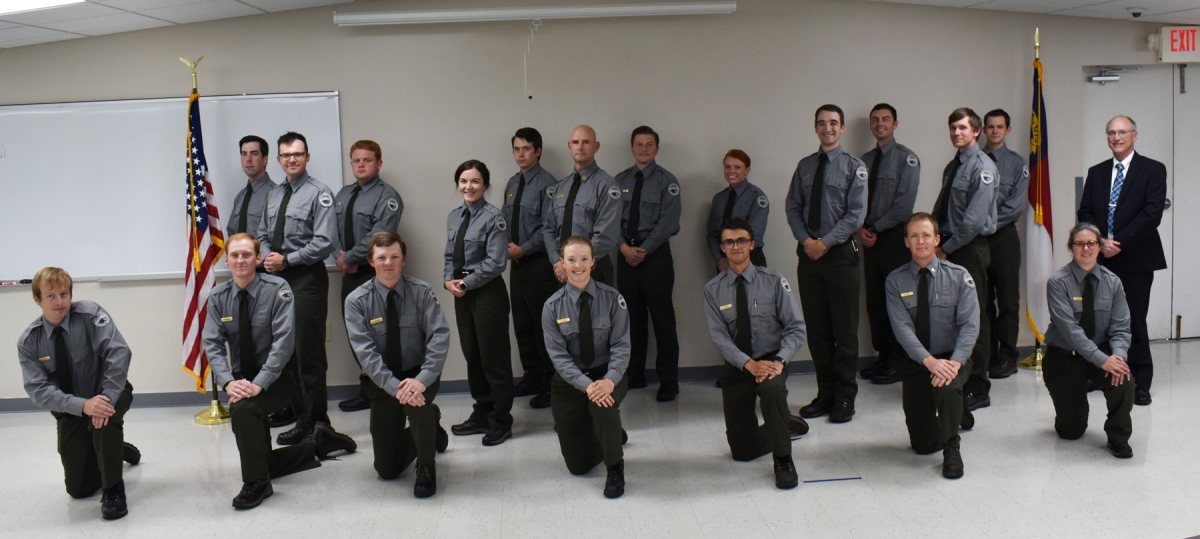 A group of law enforcement students kneel and pose for a picture