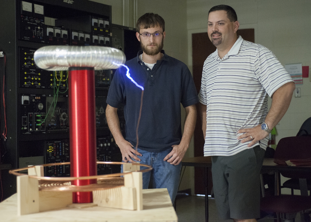 SCC Students stand with tesla coil they built.