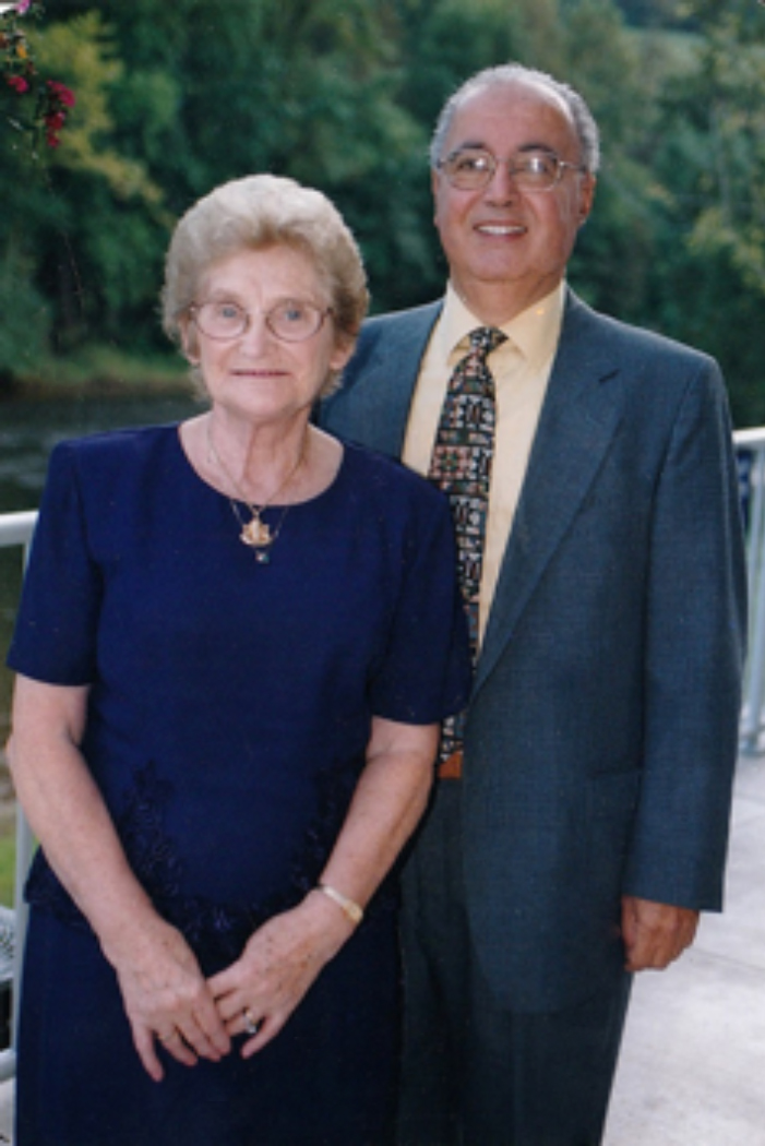 Well-dressed couple stands outdoors