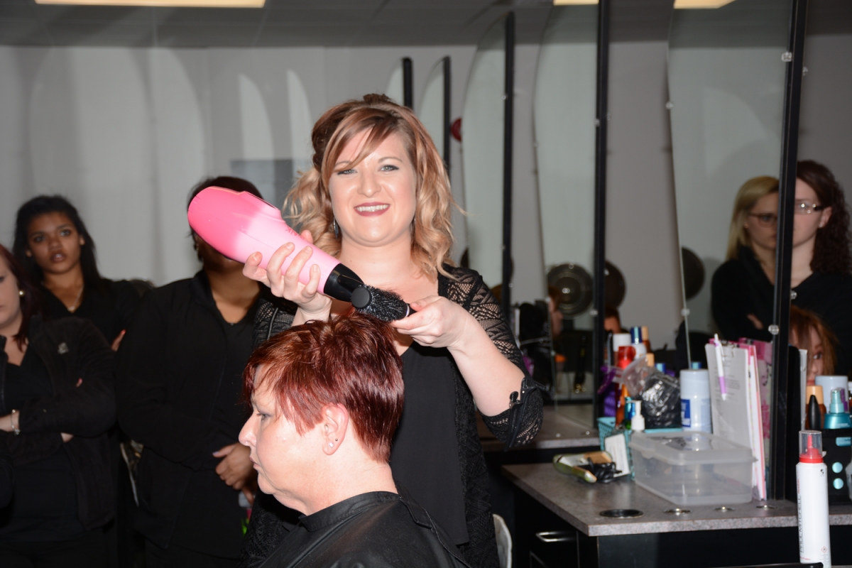 Photo of Sabrina Gunnels demonstrating hair-coloring techniques for SCC students 