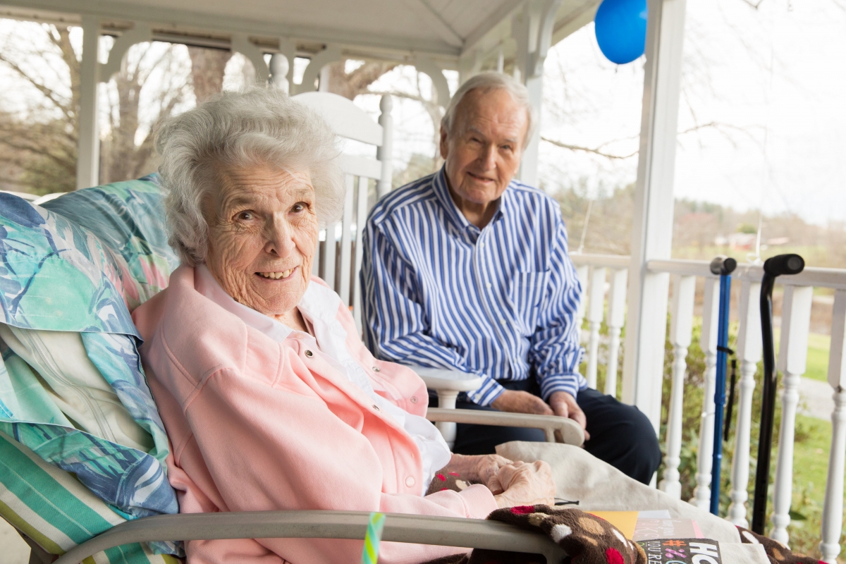 Man and woman sitting on front porch of a home