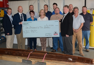Group stands with a large check.