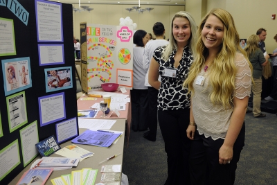 Two young ladies stand beside a display at last year's health fair.