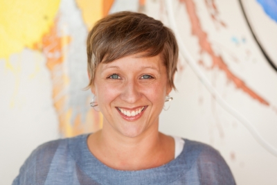 Brunette woman in gray shirt with a large smile