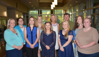 Ten students standing and smiling