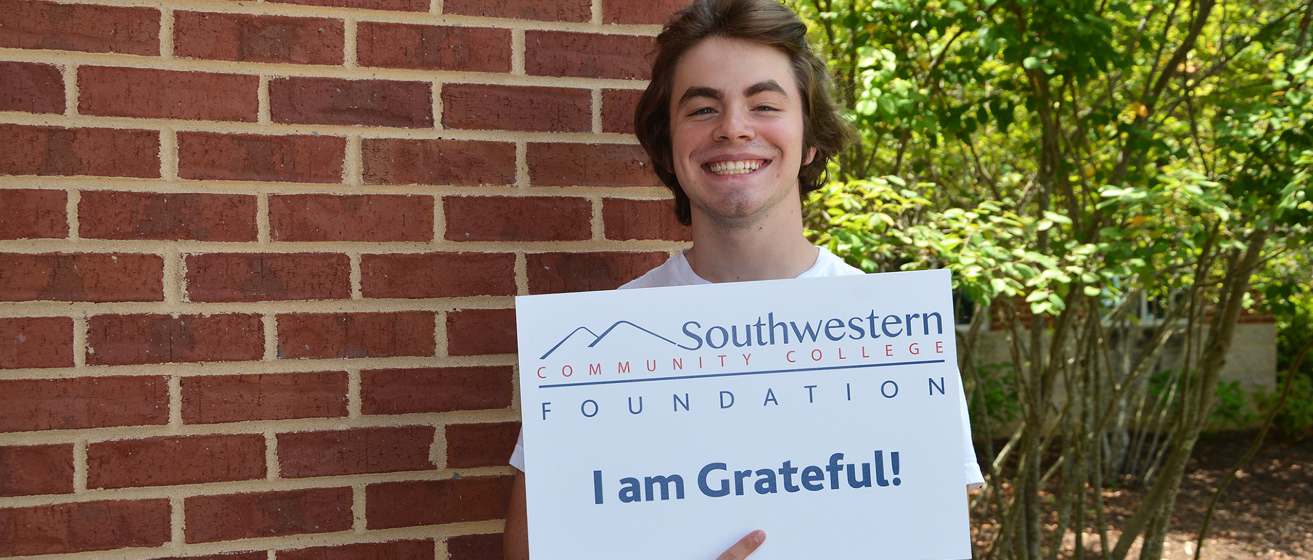 Student holds a sign thanking donors