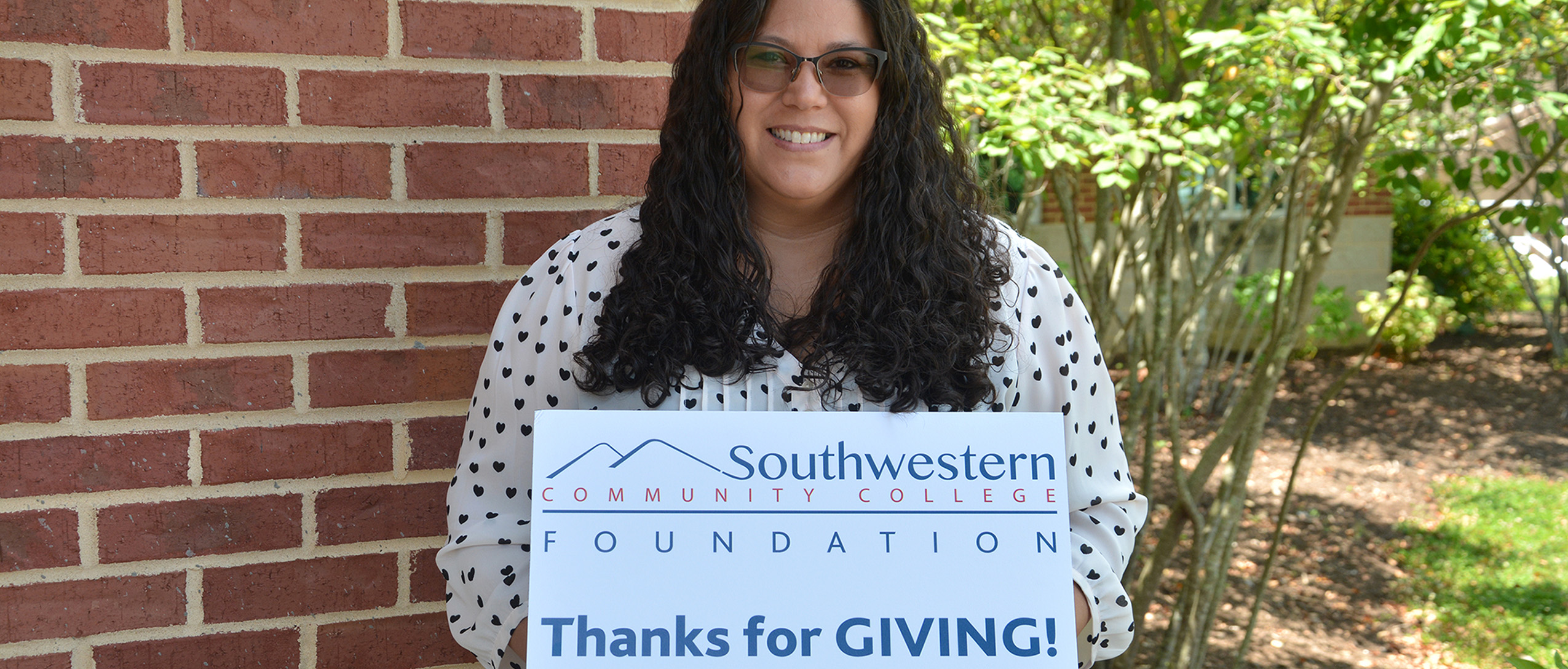 Student holds up a sign thanking donors