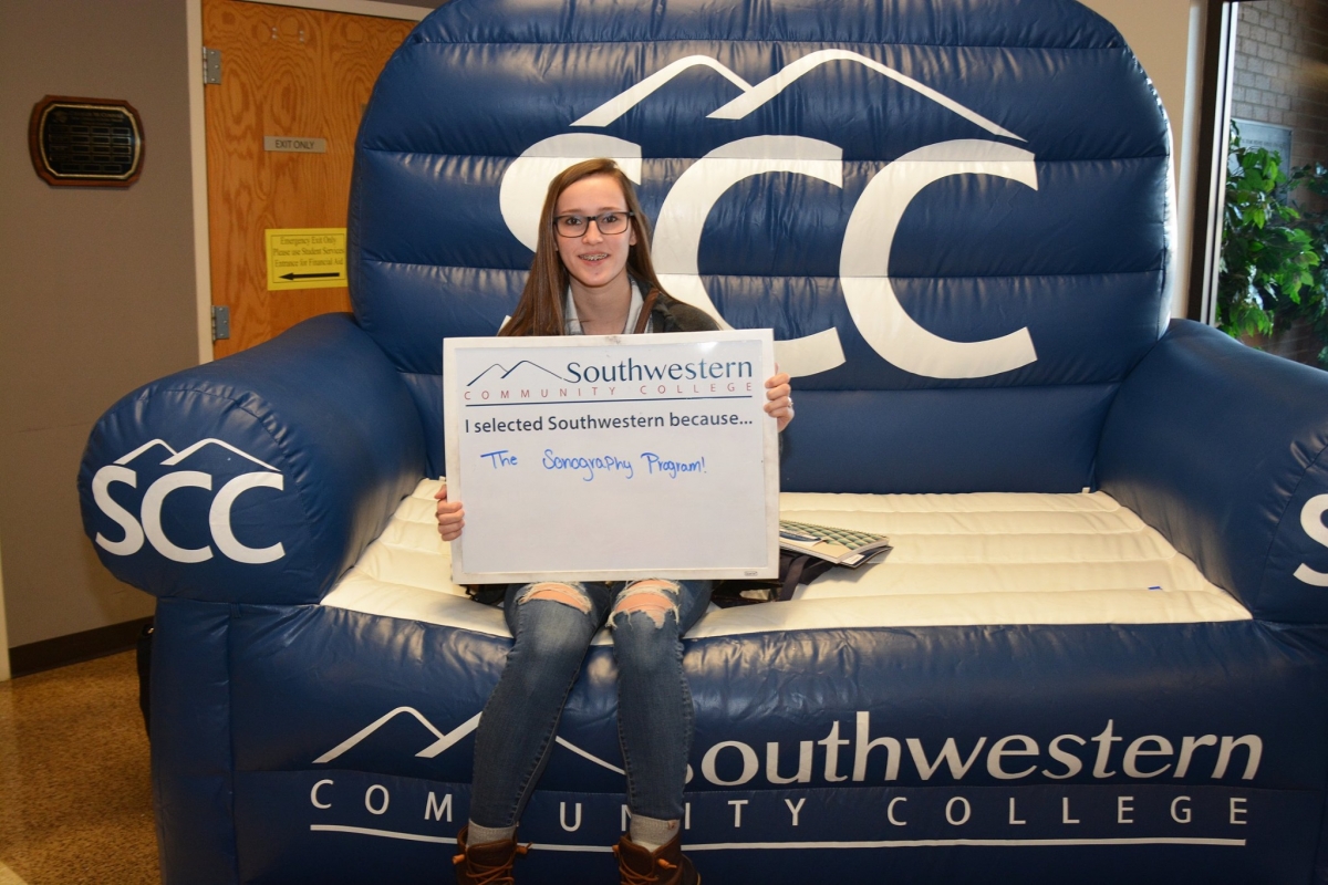 Young woman smiles as she sits on a large inflatable chair