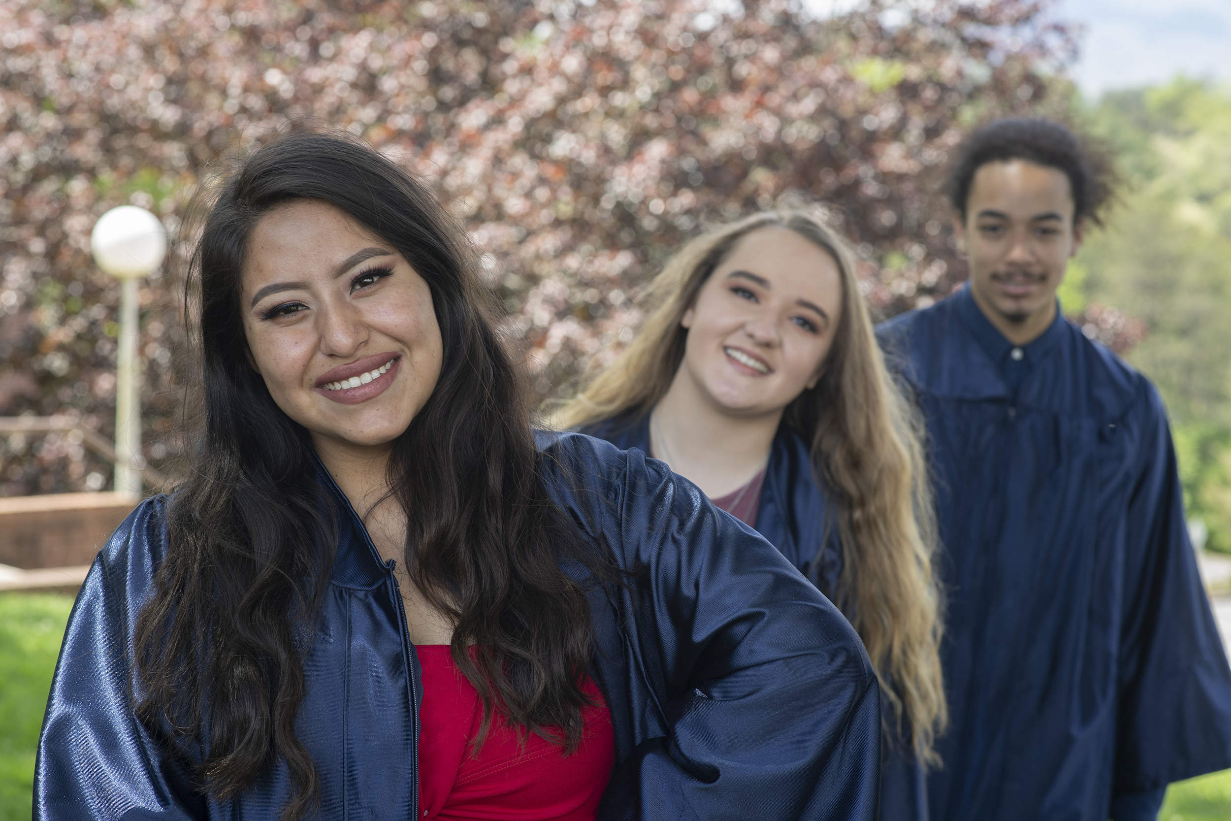 Three students wearing graduation gowns