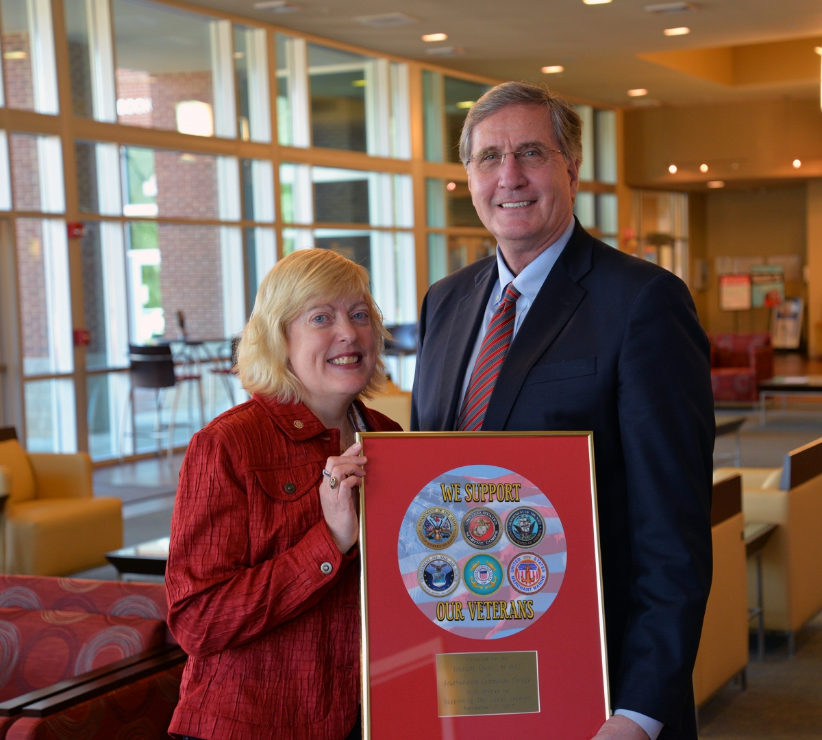 Veterans Council chair Lyn Lazar and SCC president Dr. Don Tomas holding the framed military seals.