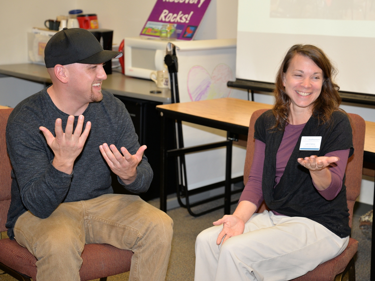 Man and Woman sit and talk in classroom at SCC.