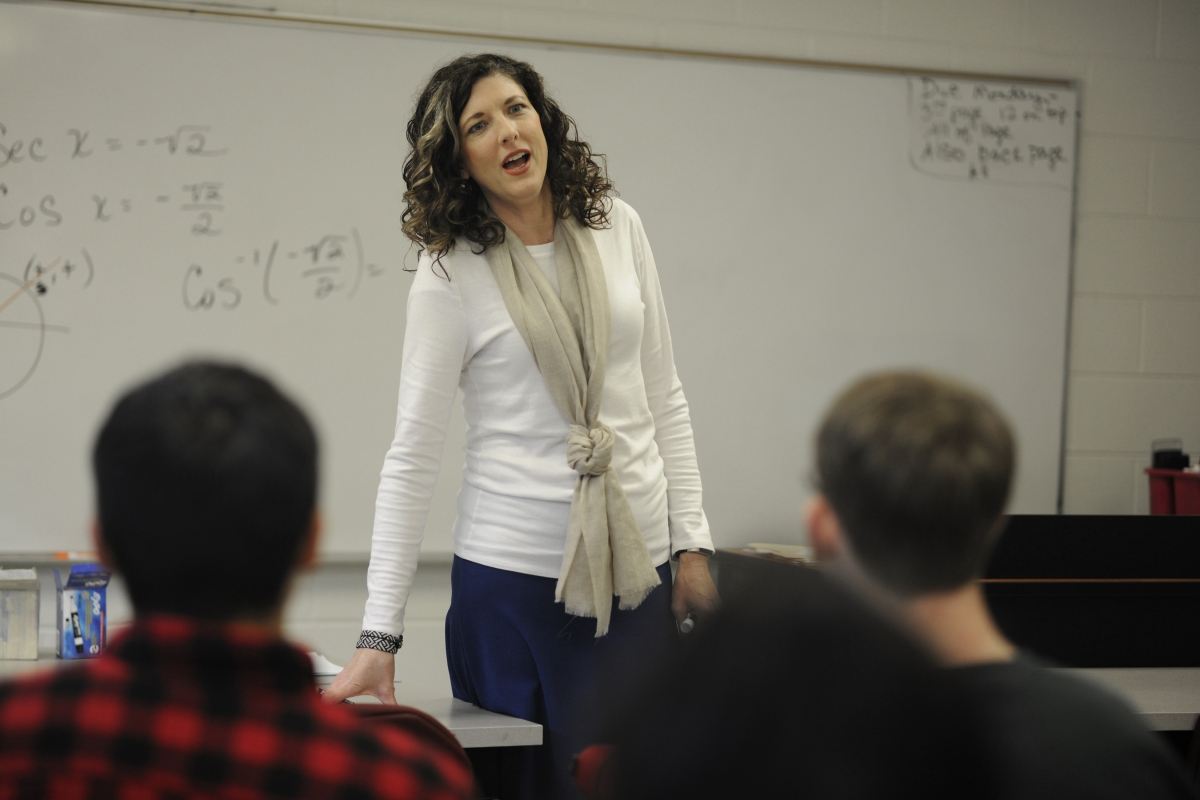 A female math instructors speaks to students