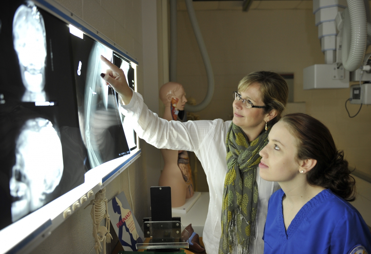 Photo of Meg Petty with student looking at Xrays
