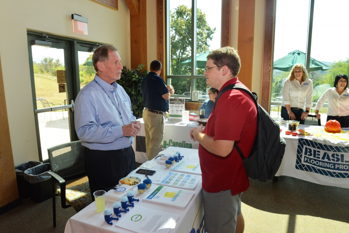 A man talks to a male student about a job opportunity