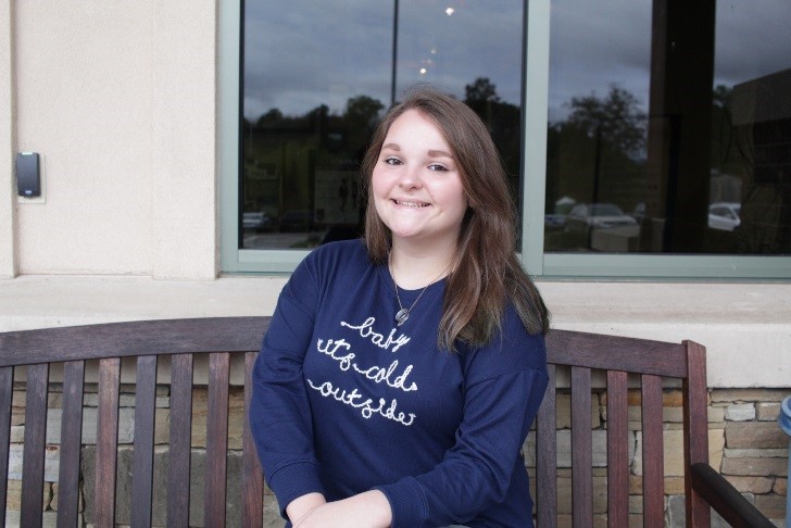 Young lady sits on a bench outside the Groves Center in Franklin.