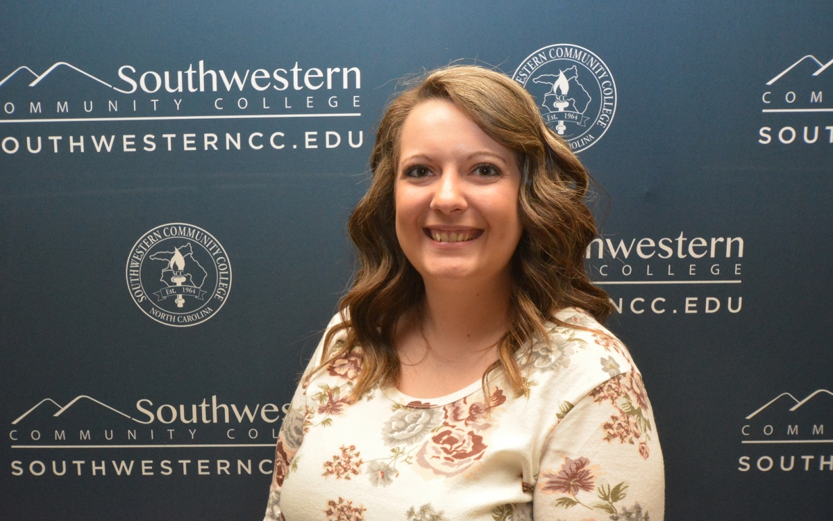 Woman stands in front of SCC backdrop