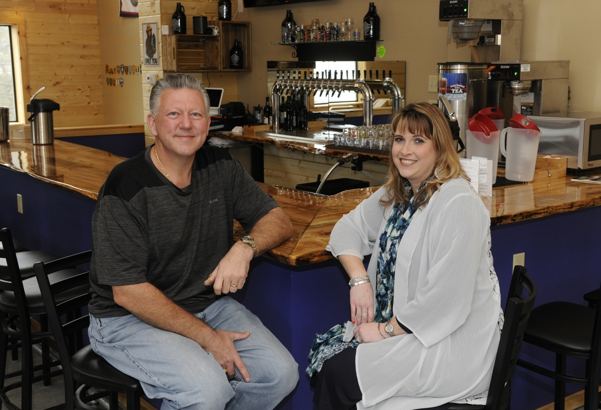 A man and a woman sit at a bar inside a brewery in Bryson City.