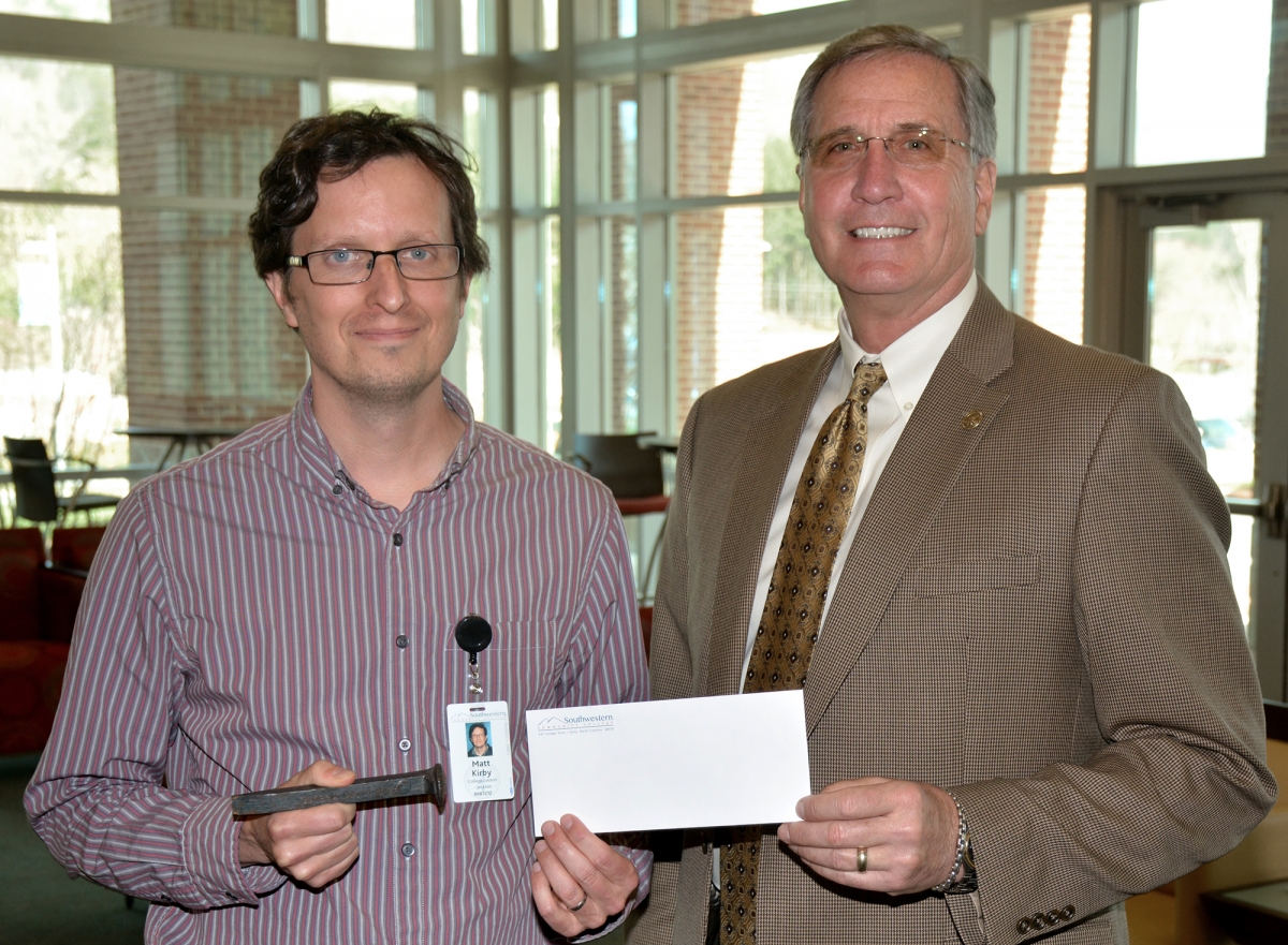 Two men exchange an envelope inside a building on SCC's Jackson Campus.