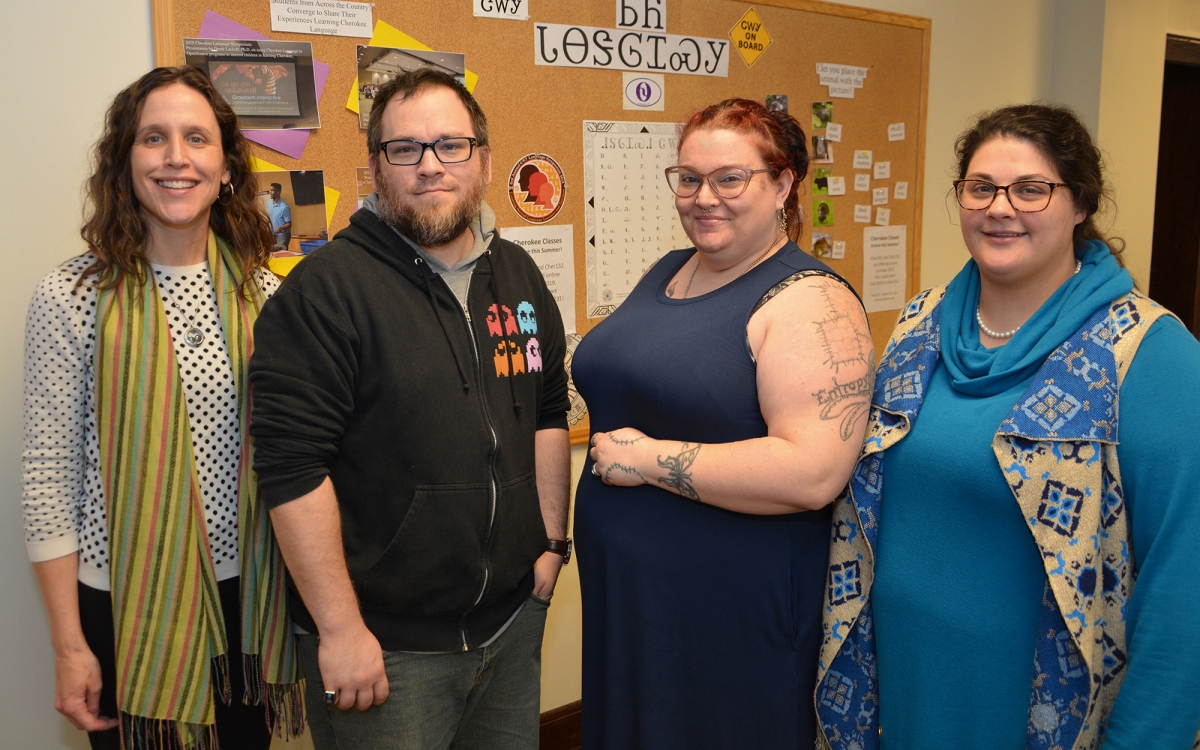 Three ladies and a man pose inside a building on WCU's campus.