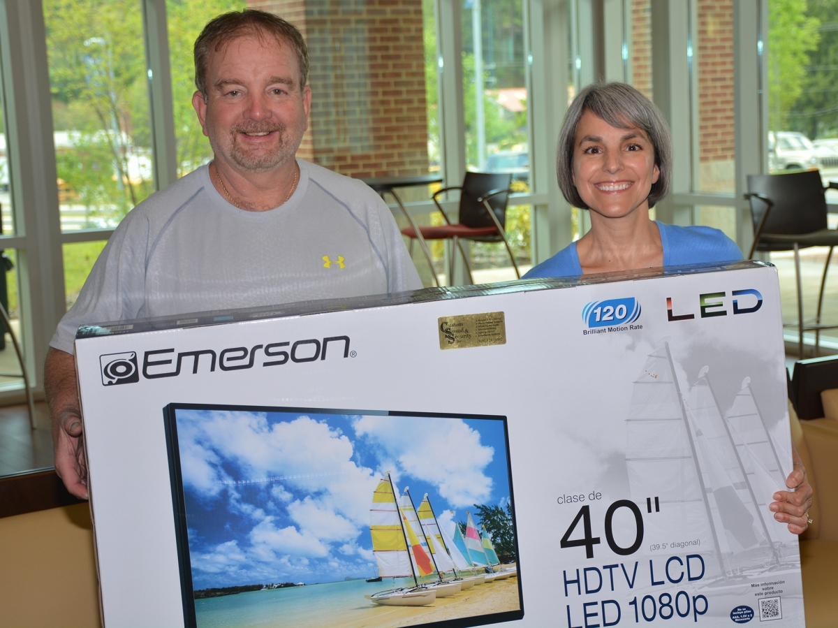 Gary Smith and Kathy Posey hold the 40-inch flatscreen TV Smith and his wife Karen recently won.