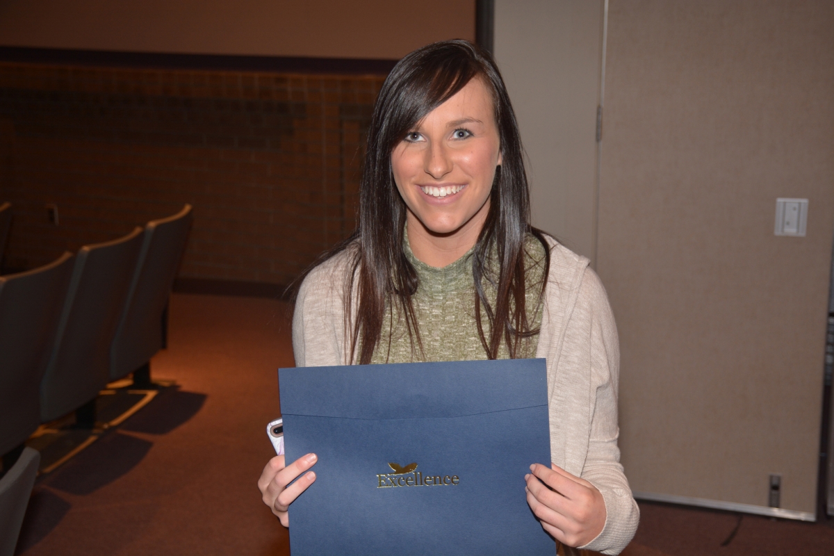 Woman holds award certificate