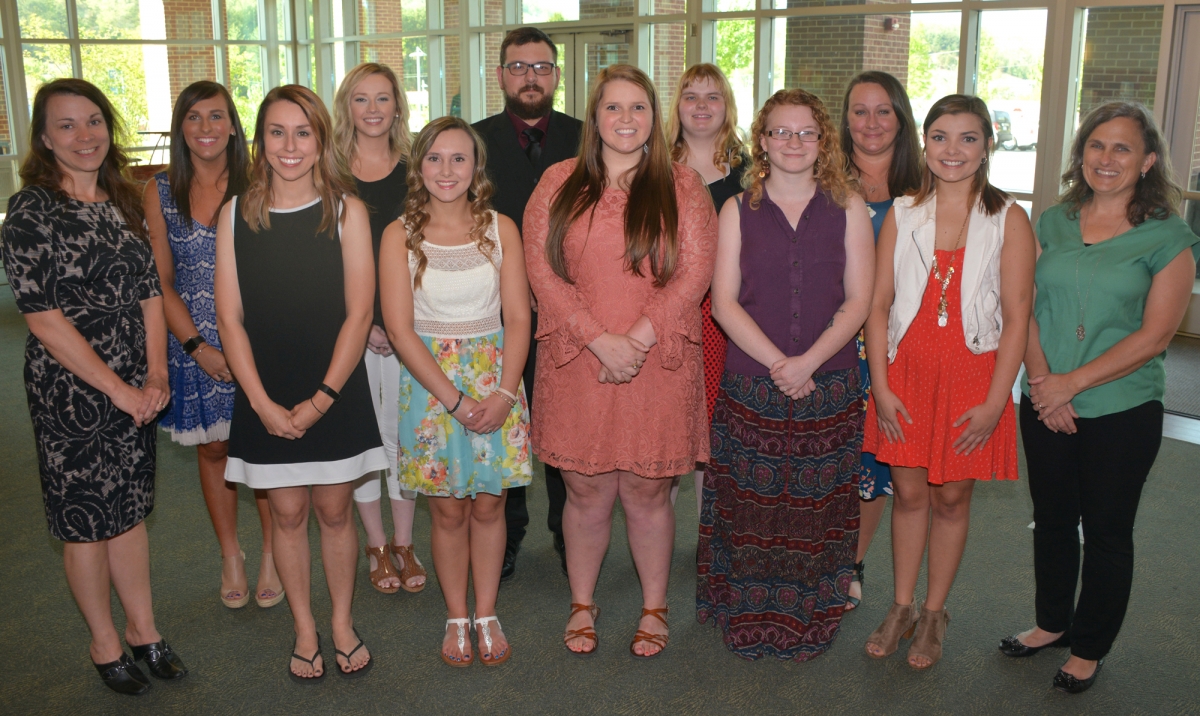 Ten students pose with their two instructors inside a building on SCC's Jackson Campus