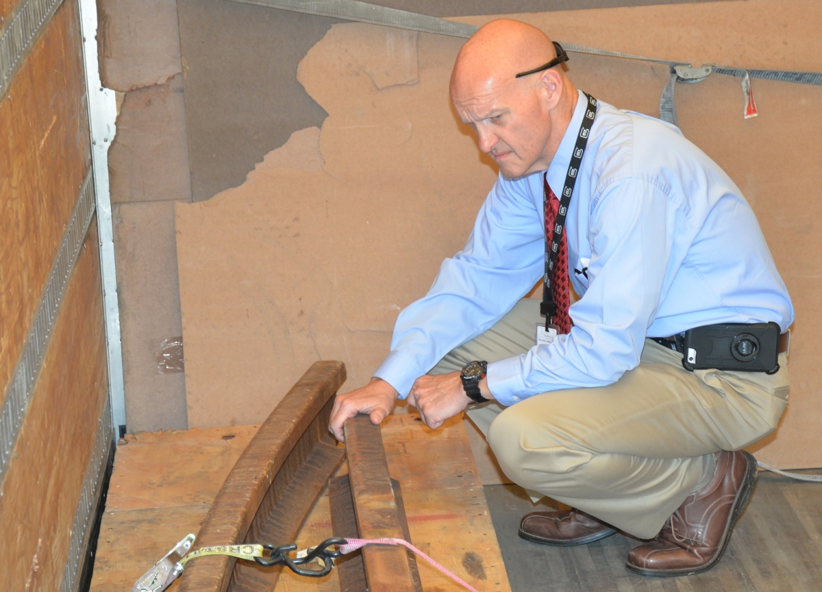 Dowdle kneels to examine the 9/11 artifacts
