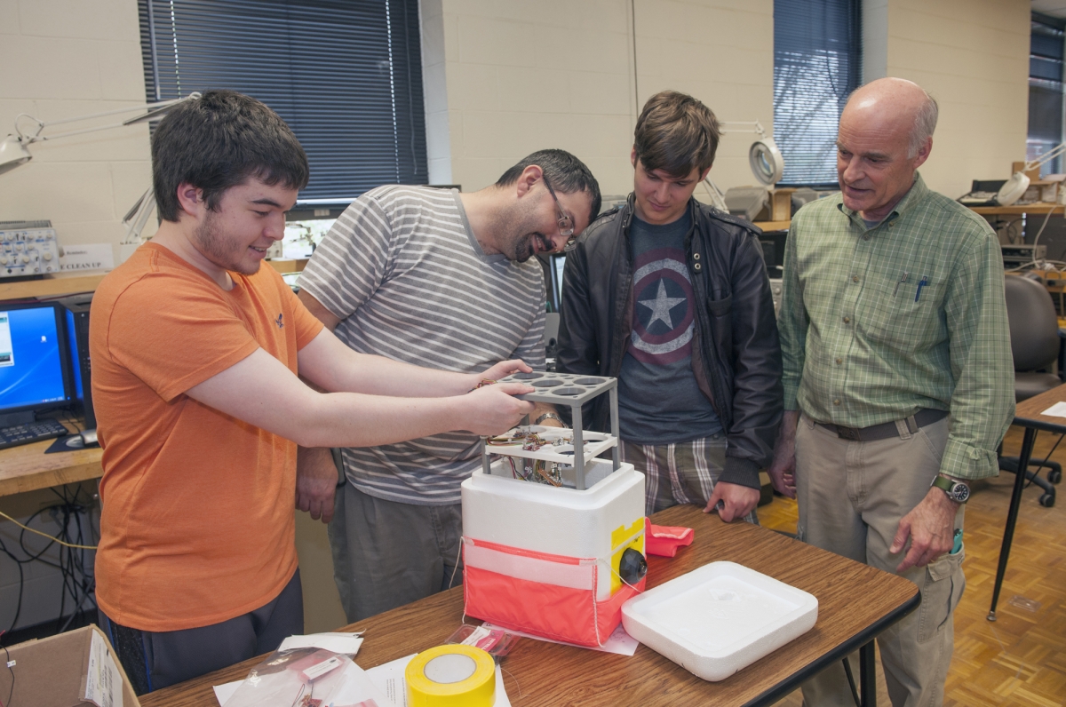 4 men looking at space object