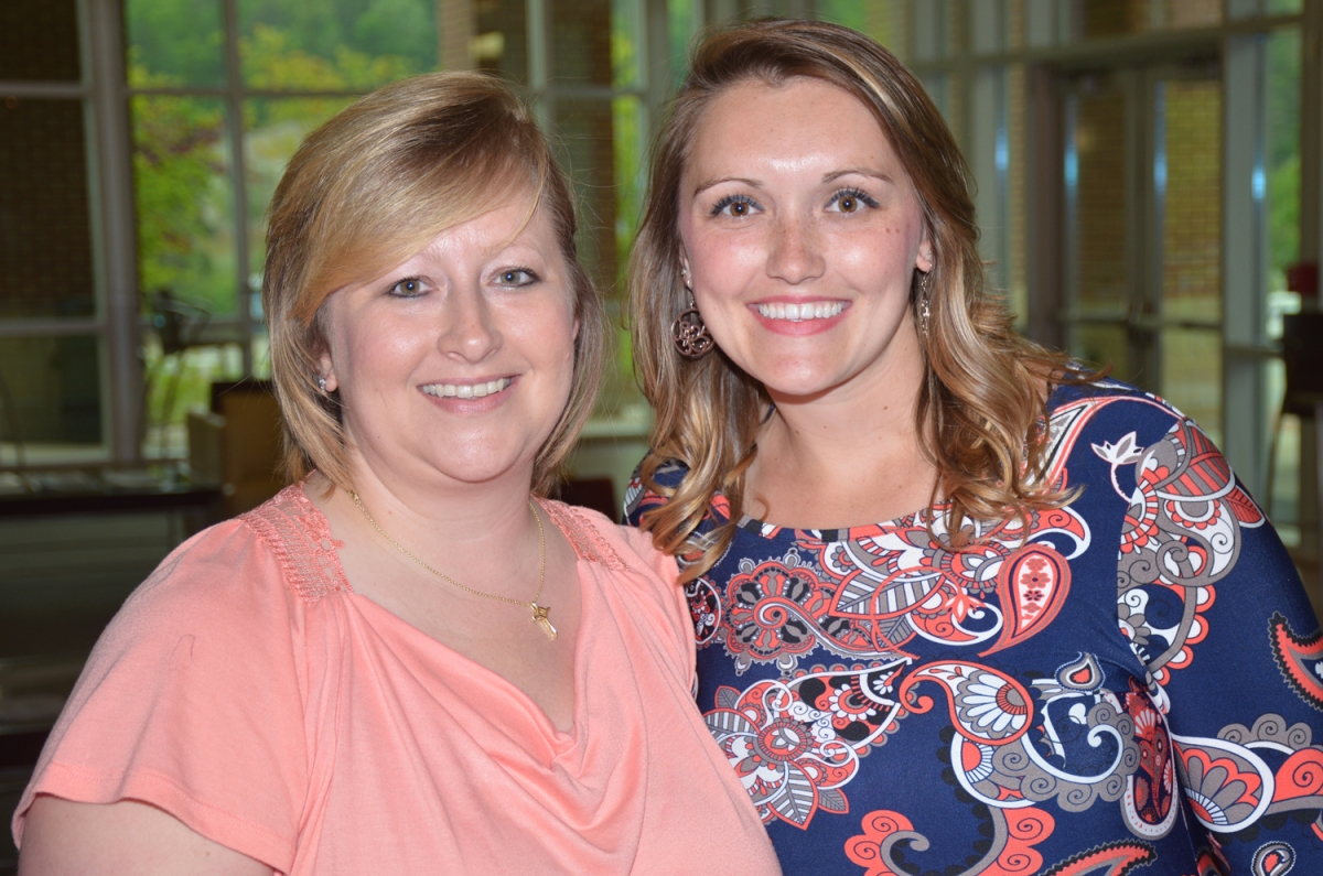 2 women standing and smiling