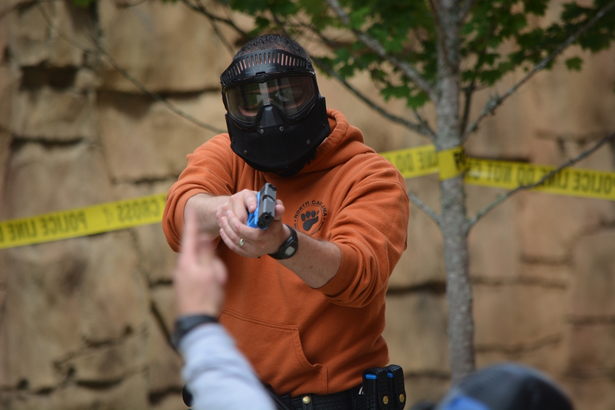 Kyle Efrid with the Jackson County Sheriff’s Office aims his pistol at a subject after disarming him during a recent training drill at SCC’s Jackson Campus in Sylva.