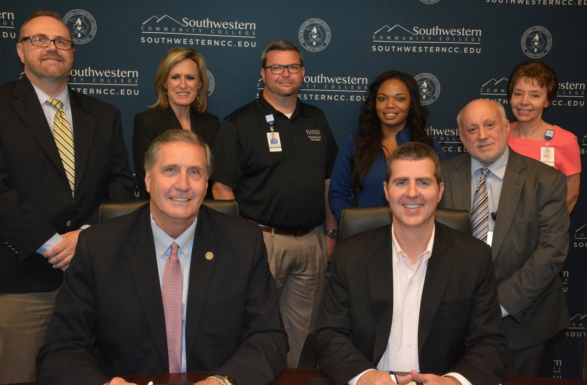 Five men and three women  are pictured in front of a blue SCC backdrop.