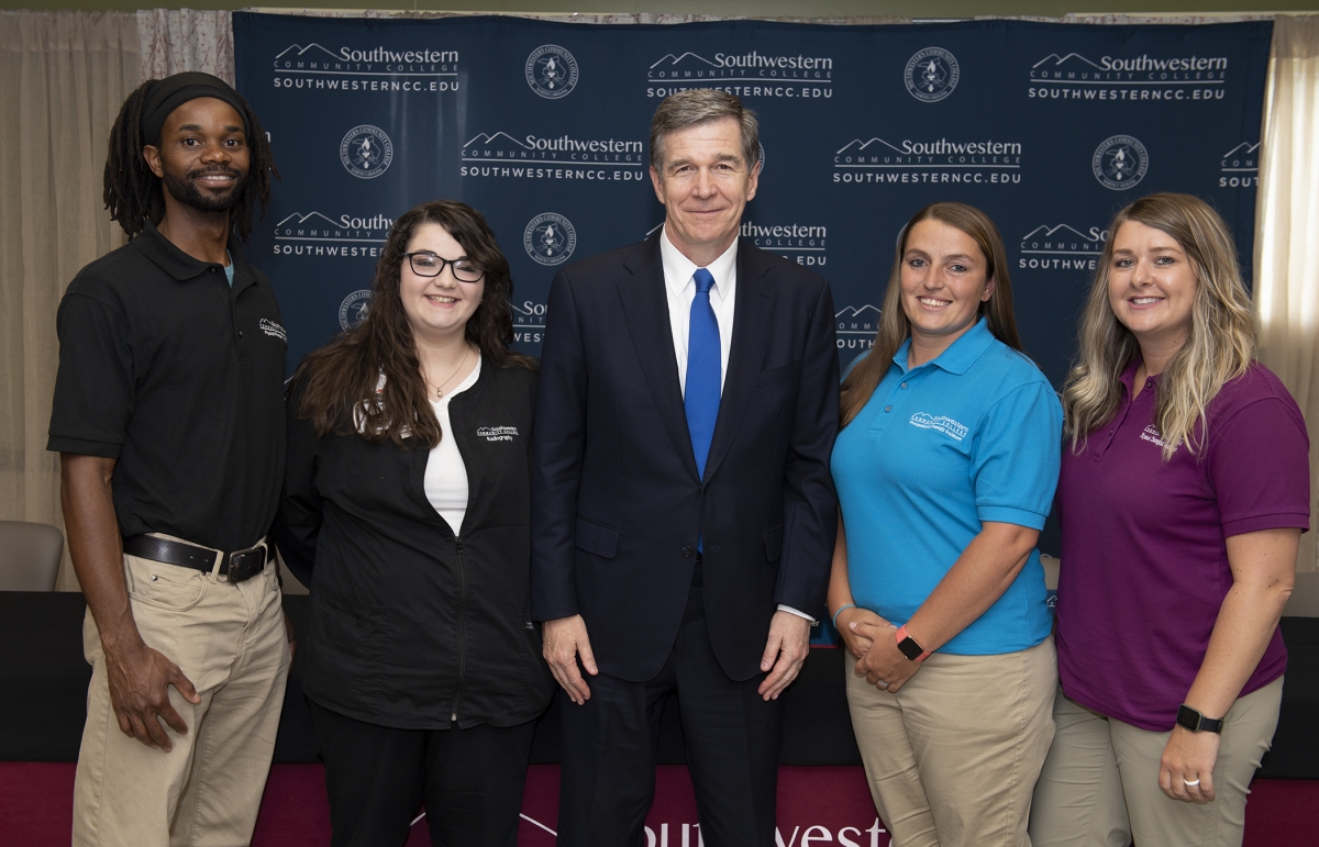 Students pose for a photo beside the governor