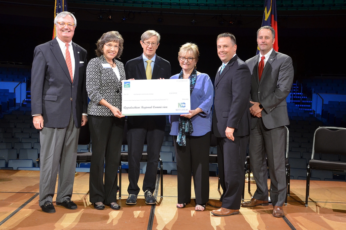 Photo of group of people holding a large check.