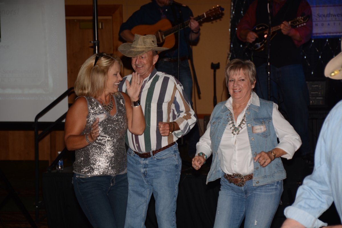 People dance at the gala as a bluegrass band plays in the background