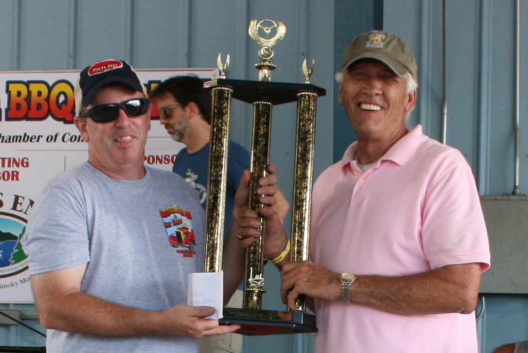 Mr. Finn receives a trophy from Mr. Myers