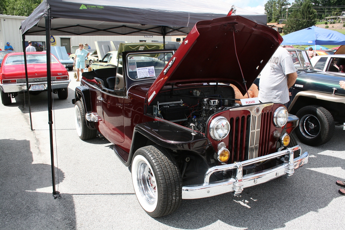 Photo of red vehicle with hood up and top down