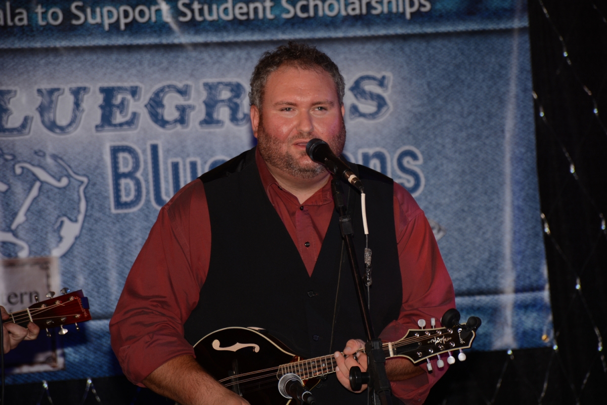 Man plays mandolin and sings.