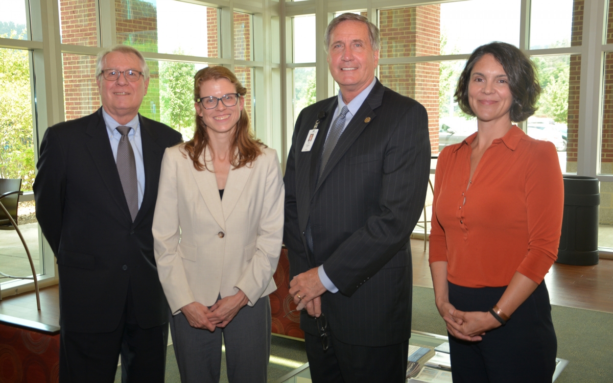 Four people pose for a photo inside SCC's Burrell Building