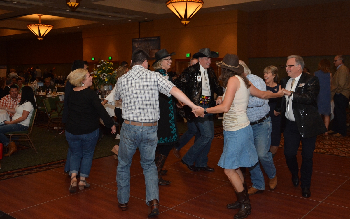 Group of people dancing in a circle inside the ballroom at Harrah's Cherokee Casino Resort