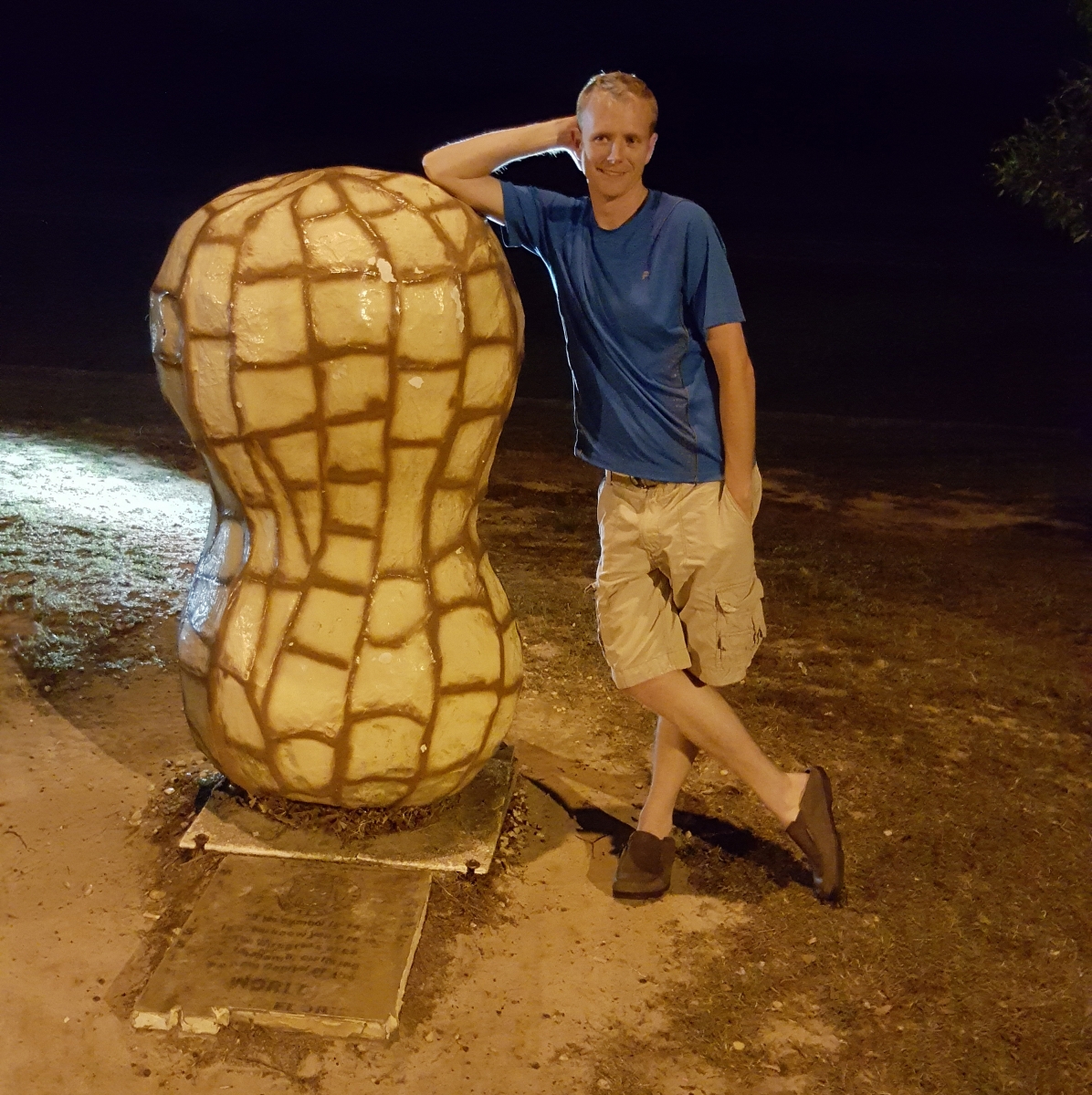 Man leans against large peanut statue