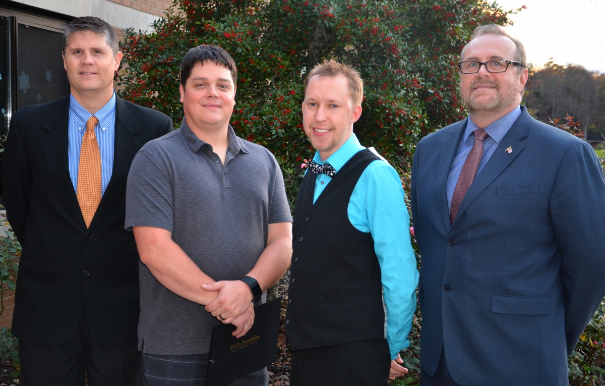 Four men stand outside a building on SCC's Jackson Campus with a tree behind them.