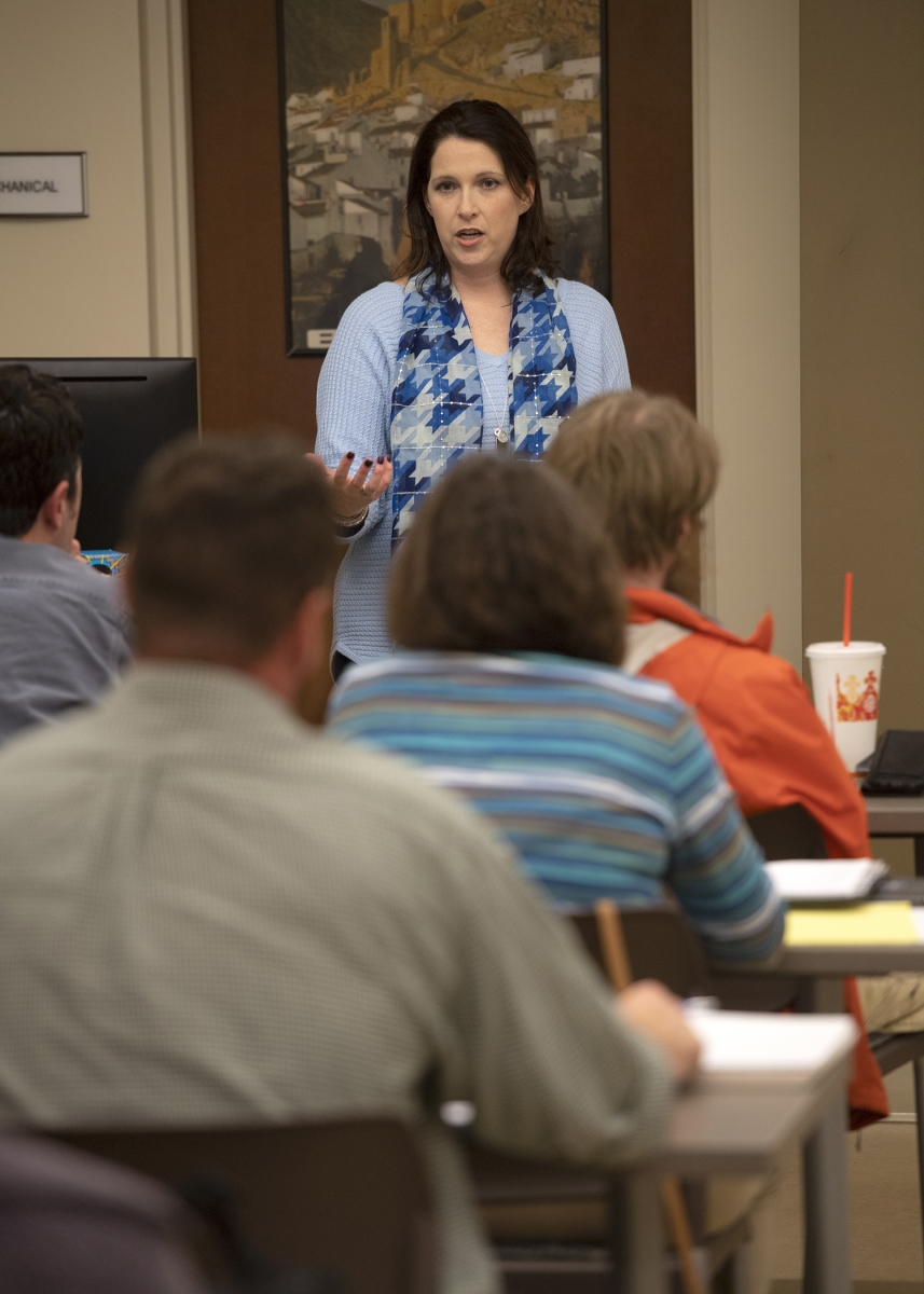 Woman speaks in front of a classroom