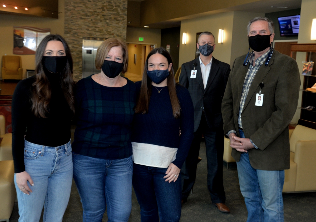 Family of Duane Young stands beside two representatives of SCC inside a building on SCC's campus.