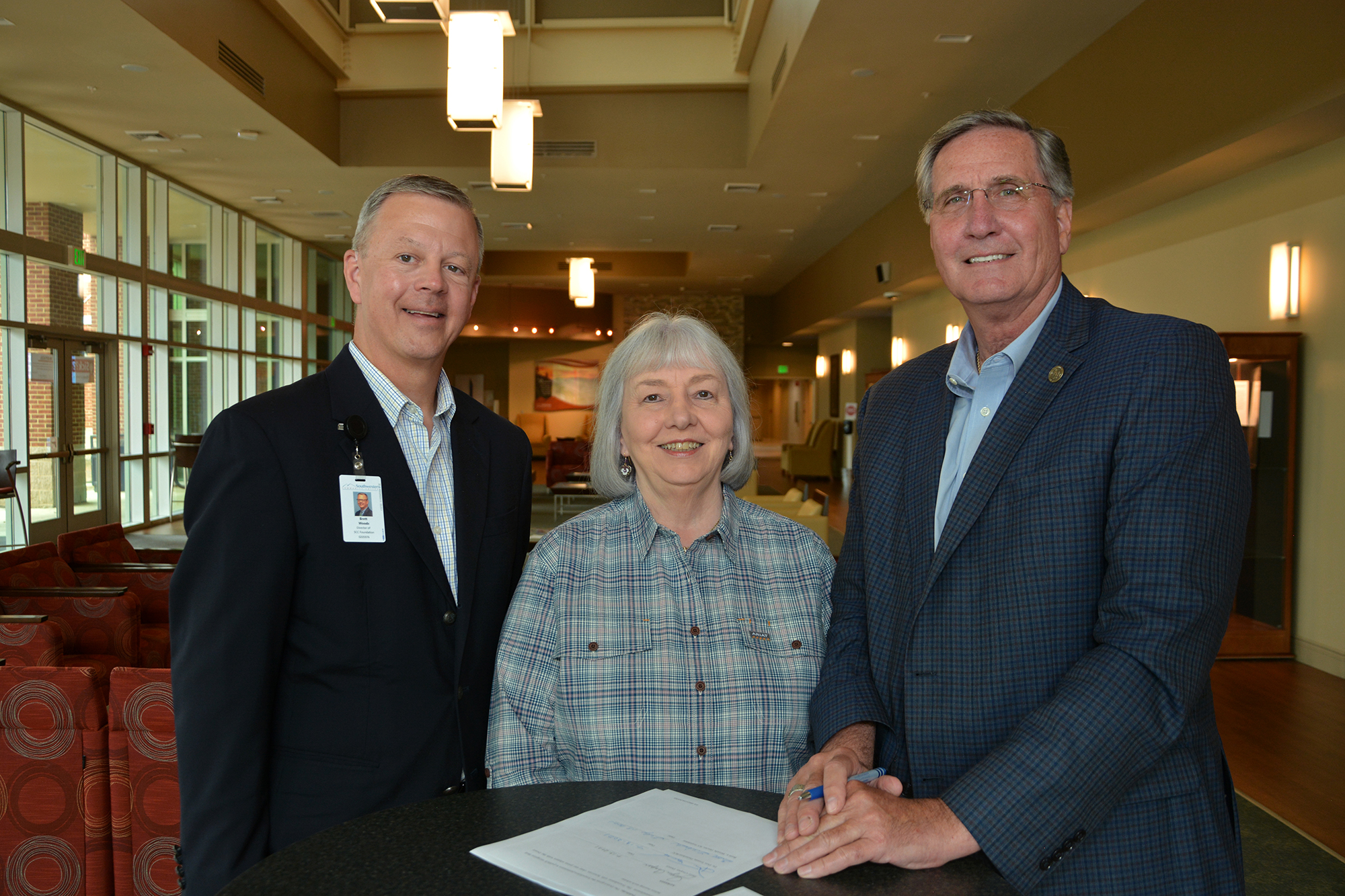 Joyce Cooper stands between Dr. Don Tomas & Brett Woods.