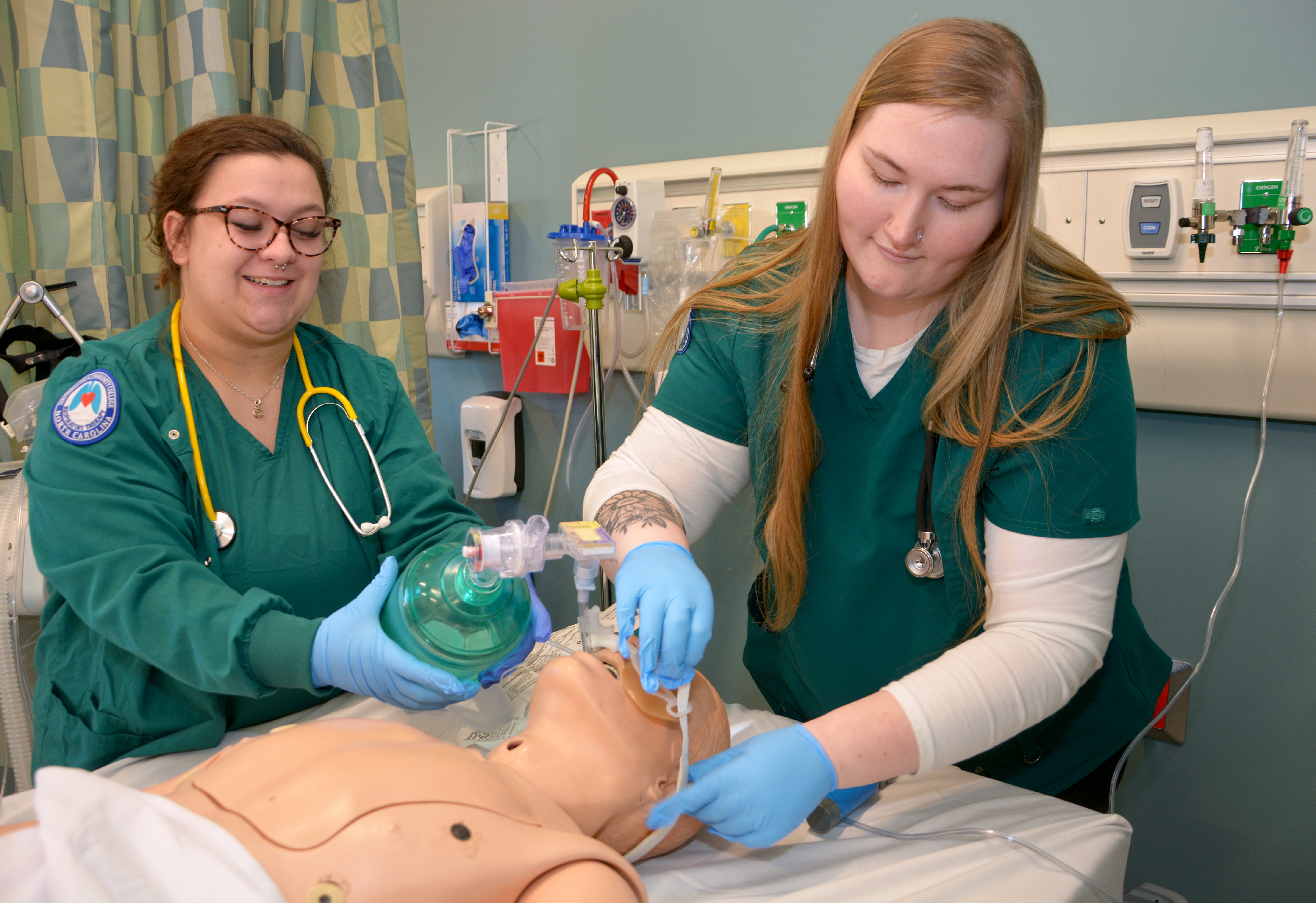 Two students work on a mannequin