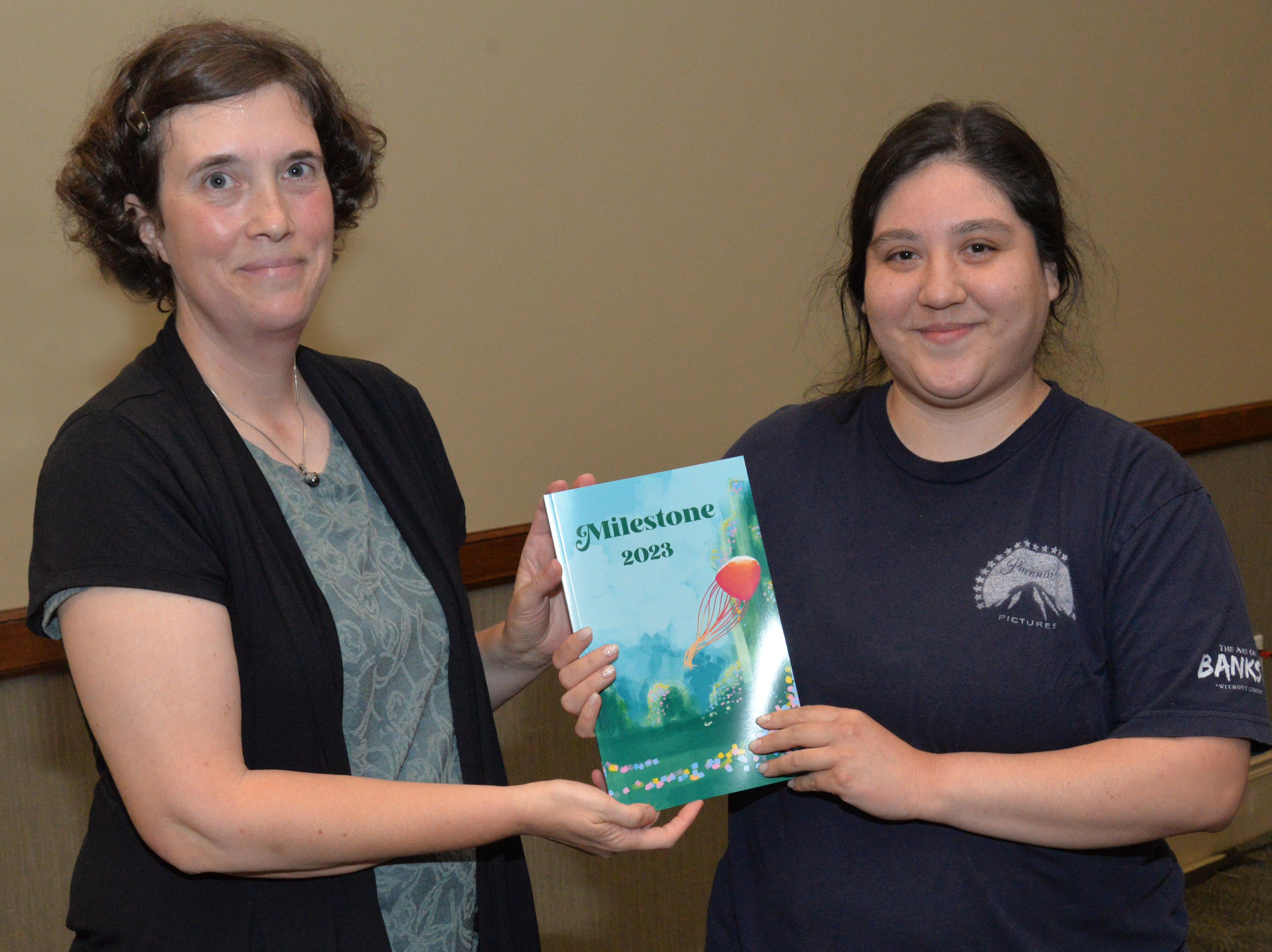 SCC Faculty Advisor Hannah Sykes (left) presents Lucia French of Cherokee with the first copy of this year’s Milestone on Tuesday, May 9, in Sylva.