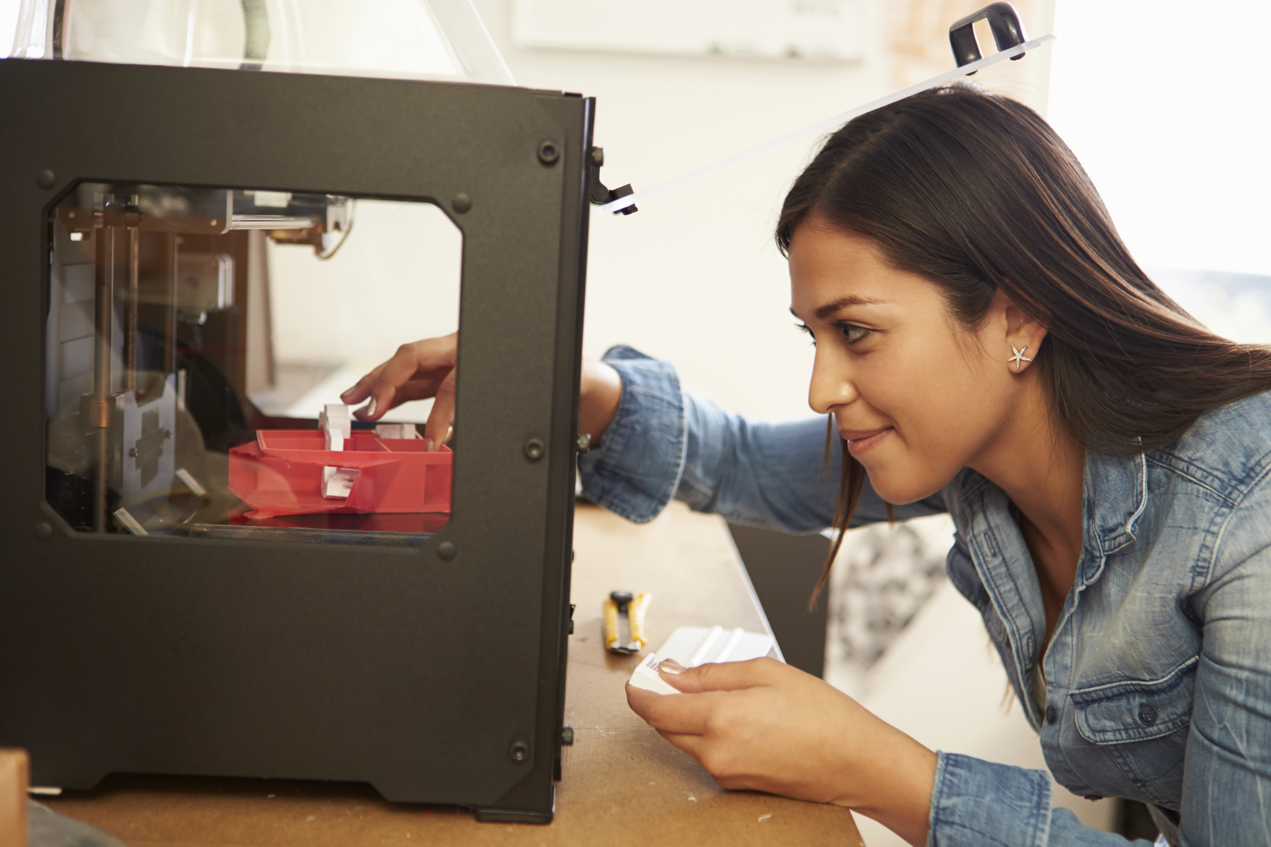 Young lady works with a 3D printer