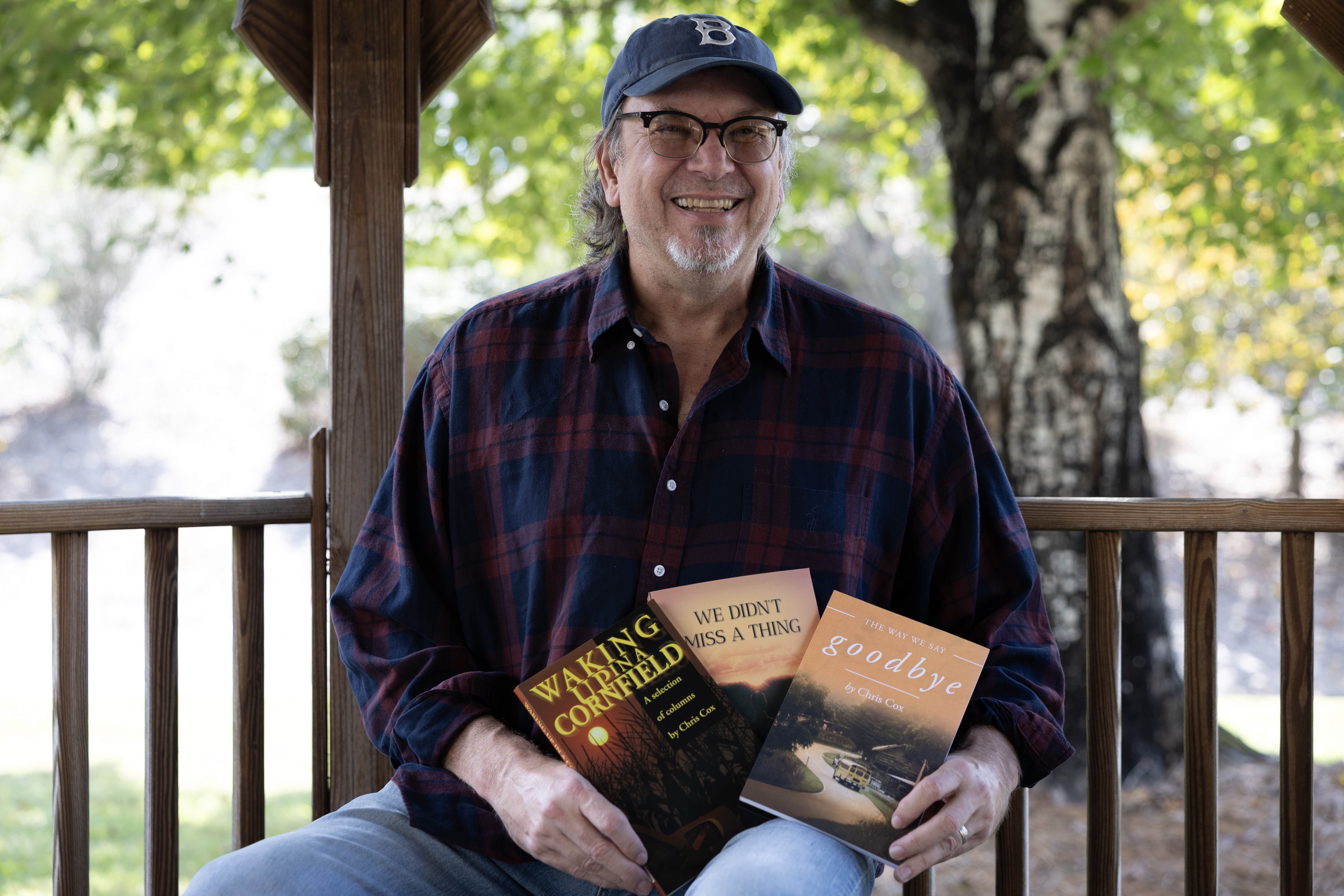 Chris Cox is shown with all three books he's written