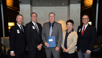 Four men and a woman pose indoors at Harrah's Cherokee Casino Resort.