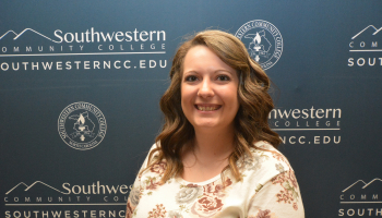 Woman stands in front of SCC backdrop